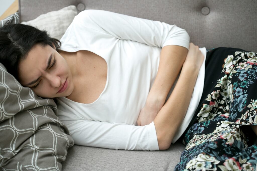 Woman stomach pain. Indoor shot.